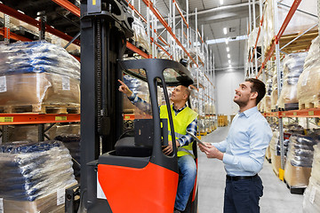 Image showing men with tablet pc and forklift at warehouse