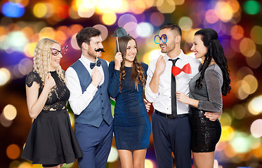 Image showing happy friends with party props over festive lights