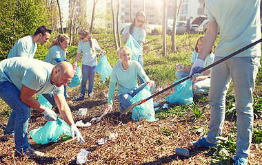 Image showing volunteers with garbage bags cleaning park area