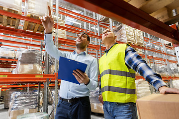 Image showing worker and businessman with clipboard at warehouse