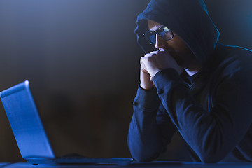 Image showing hacker with laptop computer in dark room