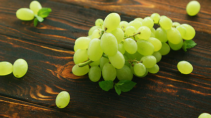 Image showing Grapes on branch on dark table 