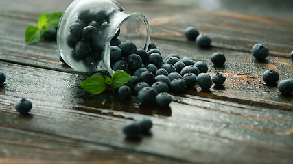 Image showing Blueberry scattering from glass jug 