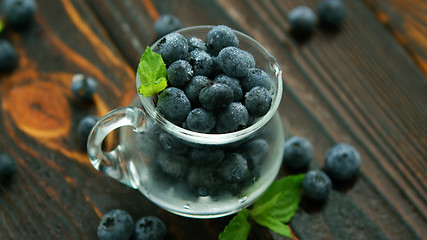 Image showing Jug full of blueberry with green leaf 