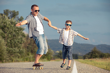 Image showing Father and son playing on the road at the day time.