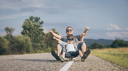 Image showing Father and son playing on the road at the day time.