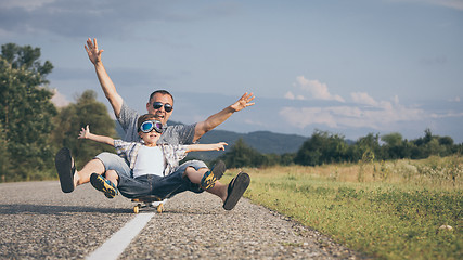 Image showing Father and son playing on the road at the day time.