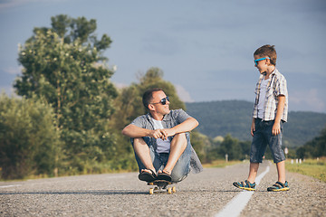 Image showing Father and son playing on the road at the day time.