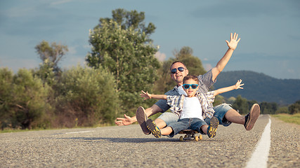 Image showing Father and son playing on the road at the day time.