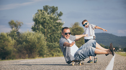 Image showing Father and son playing on the road at the day time.