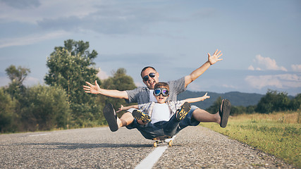 Image showing Father and son playing on the road at the day time.