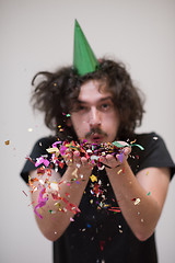 Image showing man blowing confetti in the air