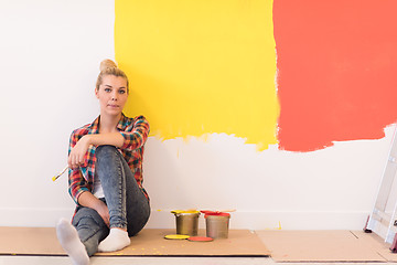 Image showing young female painter sitting on floor