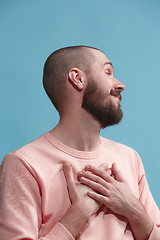 Image showing Isolated on blue young casual man smiling and enjoying at studio