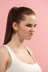 Image showing Portrait of an angry woman looking at camera isolated on a pink background