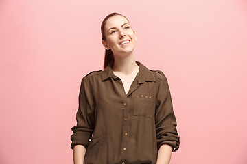 Image showing The happy business woman standing and smiling against pink background.