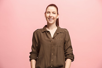 Image showing The happy business woman standing and smiling against pink background.