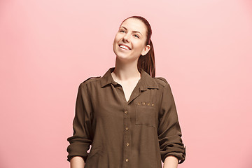 Image showing The happy business woman standing and smiling against pink background.