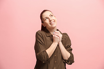 Image showing The happy business woman standing and smiling against pink background.