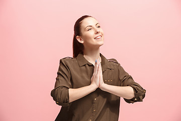 Image showing The happy business woman standing and smiling against pink background.