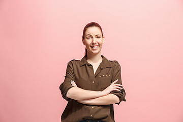 Image showing The happy business woman standing and smiling against pink background.