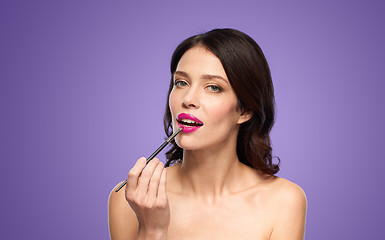 Image showing beautiful woman with make up brush for lipstick