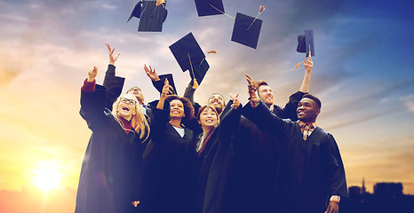 Image showing happy graduates or students throwing mortar boards