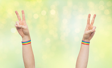 Image showing hands with gay pride rainbow wristbands make peace