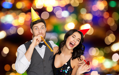 Image showing happy couple with party blowers having fun