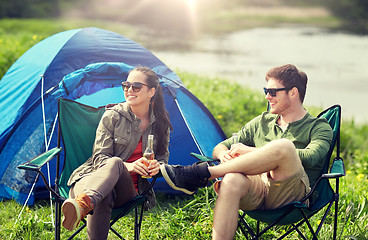 Image showing happy couple drinking beer at campsite tent