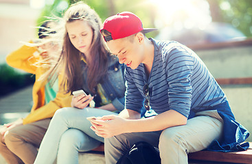 Image showing happy teenage friends with smartphones outdoors