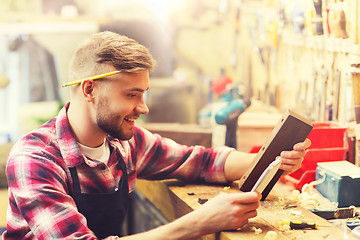 Image showing carpenter working with wood plank at workshop