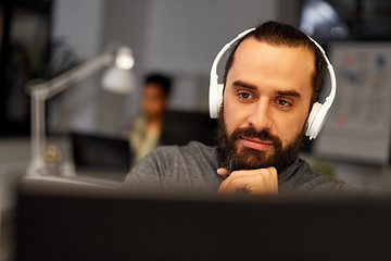 Image showing creative man with headphones working at office