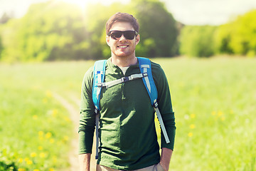 Image showing happy young man with backpack hiking outdoors