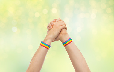 Image showing hands with gay pride wristbands in winning gesture