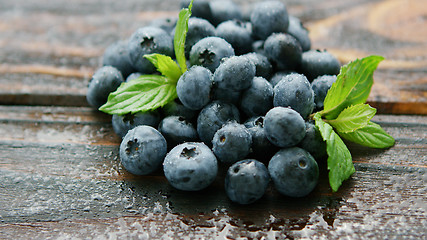 Image showing Fresh blueberry and green leaf on table 