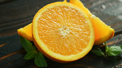 Image showing Sliced orange with green leaves 