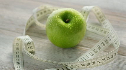 Image showing Green apple and tape measure 