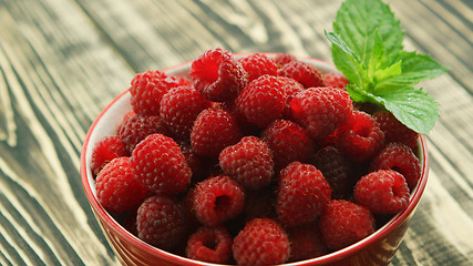 Image showing Bowl of raspberry on wooden desk 