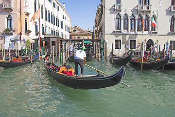 Image showing Venetian gondolier in the gondola is transported tourists throug