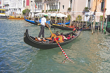 Image showing Venetian gondolier in the gondola is transported tourists throug