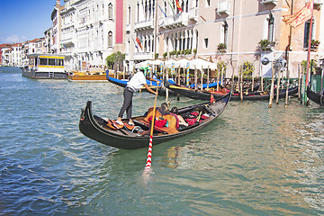 Image showing Venetian gondolier in the gondola is transported tourists throug