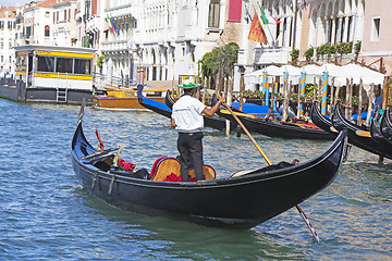 Image showing Venetian gondolier in the gondola is transported tourists throug