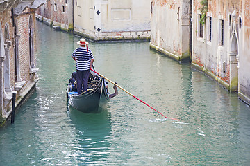 Image showing Venetian gondolier in the gondola is transported tourists throug