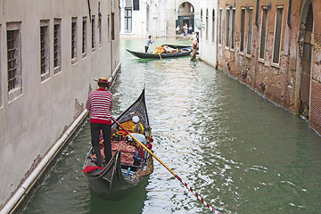 Image showing Venetian gondolier in the gondola is transported tourists throug