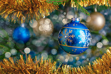 Image showing Christmas-tree decoration bauble on decorated Christmas tree bac