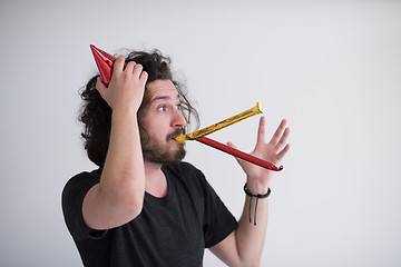 Image showing Portrait of a man in party hat blowing in whistle