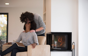 Image showing multiethnic couple hugging in front of fireplace