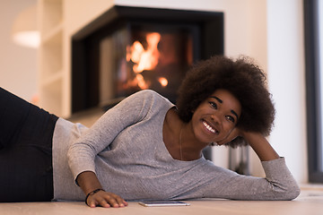 Image showing black women using tablet computer on the floor