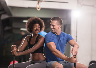 Image showing multiethnic couple after workout with hammer